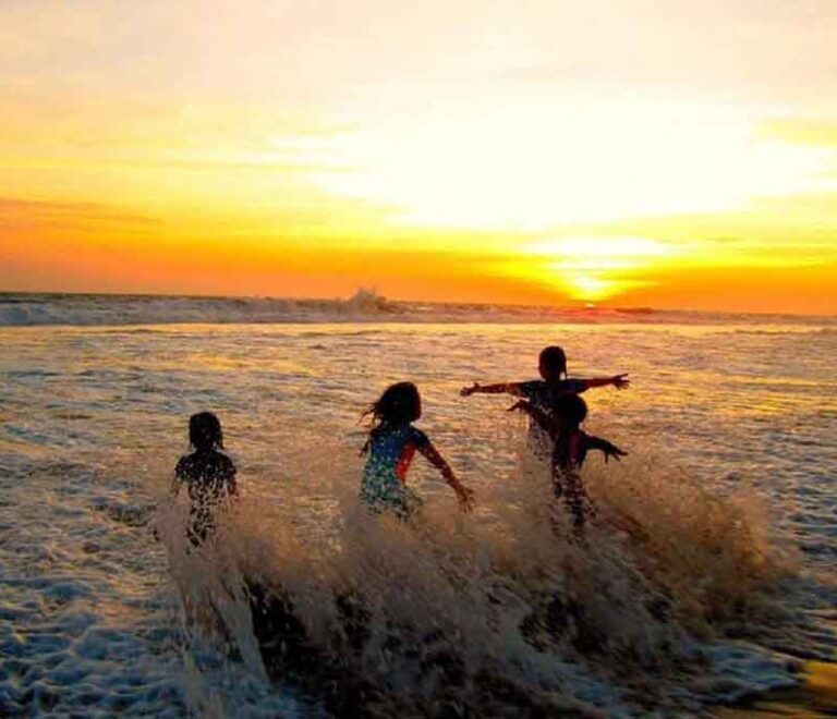 Children playing waves on the beach of Sawarna