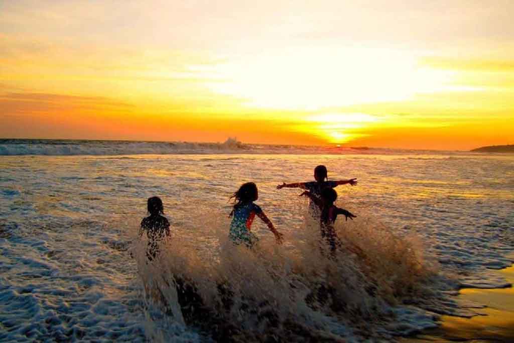Children playing waves on the beach of Sawarna