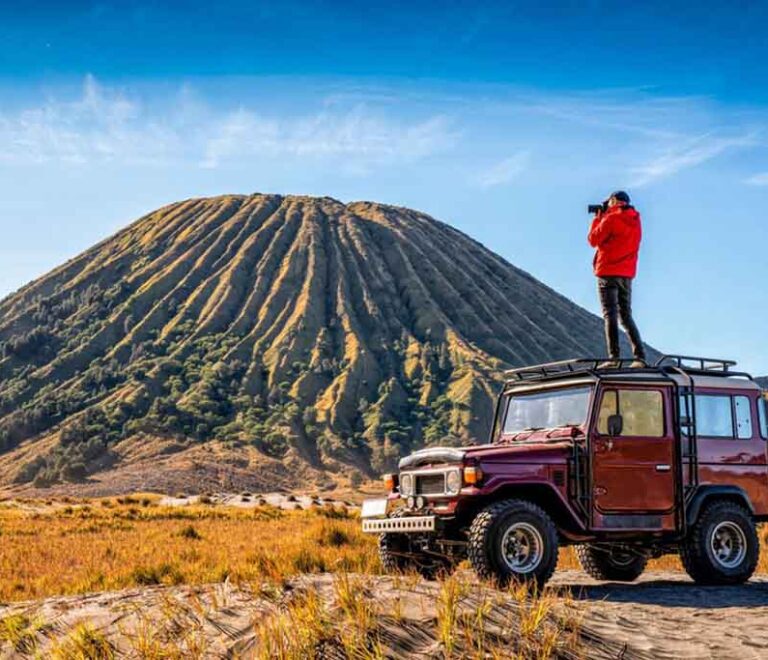 In the top of Jeep Hardtop view Mount Batok in Bromo
